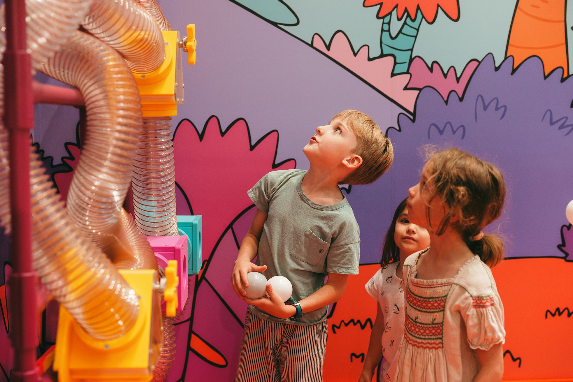 a little girl riding on a green slide